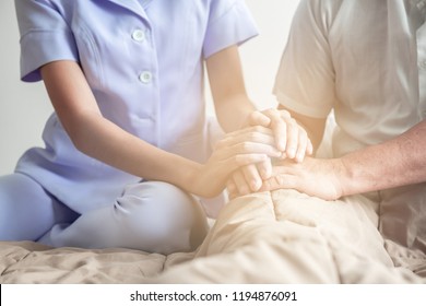 Comforting Hand. Young Nurse Holding Old Man's Hand. Senior Care, Care Taker And Senior Retirement Home Service Concept. Close Up Shot.