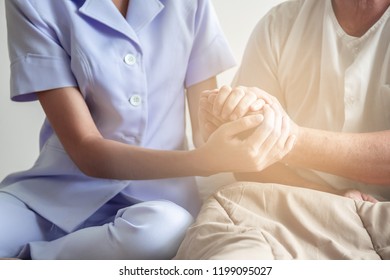 Comforting Hand. Young Nurse Holding Old Man's Hand. Senior Care, Care Taker And Senior Retirement Home Service Concept. Close Up Shot.