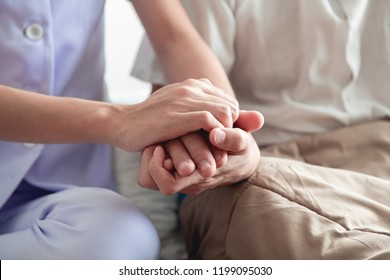 Comforting Hand. Young Nurse Holding Old Man's Hand. Senior Care, Care Taker And Senior Retirement Home Service Concept. Close Up Shot.