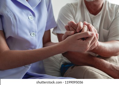 Comforting Hand. Young Nurse Holding Old Man's Hand. Senior Care, Care Taker And Senior Retirement Home Service Concept. Close Up Shot.