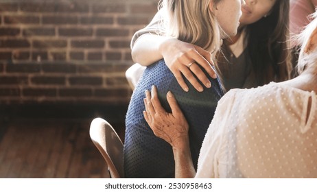 A comforting scene with three women sharing support. One woman embraces another, showing care and empathy. Friendship and support among women is highlighted. Sad woman getting support in group. - Powered by Shutterstock