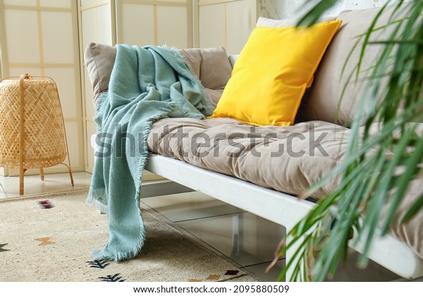Comfy couch with\
plaid in modern living\
room