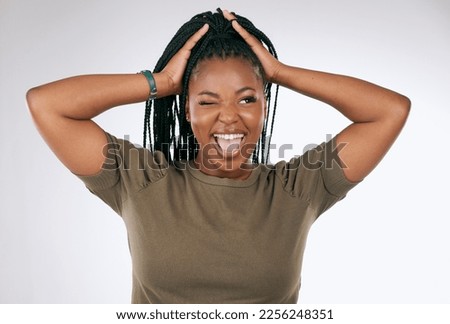 Comic, funny and black woman with a crazy face isolated on a grey studio background. Smile, happy and African girl model with tongue sticking out for comedy, happiness and goofy on a backdrop