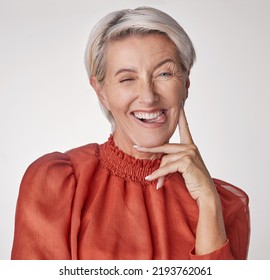 Comic Portrait, Quirky Model Or Playful Mature Woman On Gray Studio Background With Funny Facial Expression, Tongue Or Happy Wink Face. Silly, Classy Fashion And Elegant Stylish Beauty Or Cool