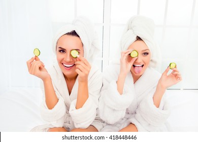 Comic young sisters after shower making mask with cucumber - Powered by Shutterstock