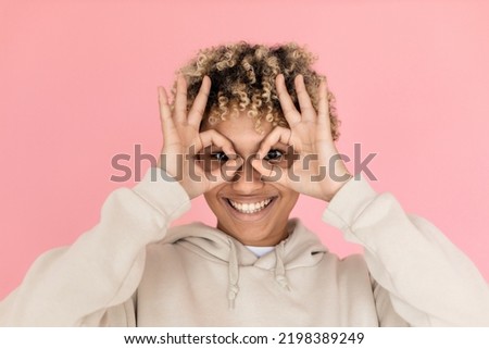Comical African American woman making funny face. Female model with curly hair fooling around. Portrait, emotion concept