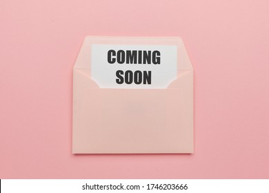 Coming soon mail concept. Sending letters with advertising information about the imminent opening. Marketing (promote) envelope on pink background.