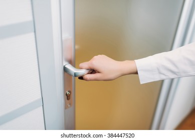 Coming to work, woman's hand opens the door