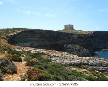 COMINO, MALTA - Apr 27, 2014: Santa Marija Tower, built by Knights Order of St John, over the cliffs and blue sea on the island of Comino, Malta. Prison in Count of Monte Cristo