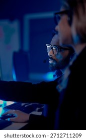Command center lead focused intense monitoring critical systems late night headset connects team analyzing real time data screen crucial vigilance protects infrastructure operation underway now execut