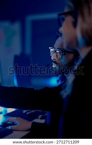 Command center lead focused intense monitoring critical systems late night headset connects team analyzing real time data screen crucial vigilance protects infrastructure operation underway now execut