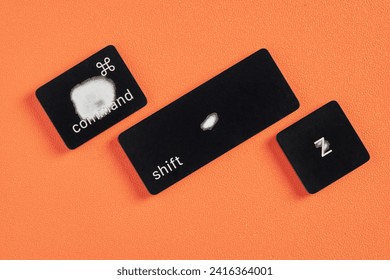 The command key, shift key and Z key are worn out due to frequent use and are removed from a keyboard with orange background