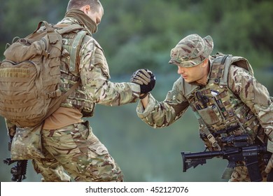 Command Rangers During The Military Operation. Soldiers Climbing On Mountain, One Of Them Giving Hand And Helping To Climb. Help, Support, Assistance In A Dangerous Situation