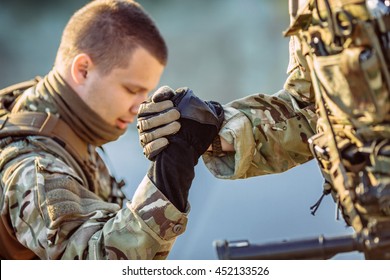 Command Rangers During The Military Operation. Soldiers Climbing On Mountain, One Of Them Giving Hand And Helping To Climb. Help, Support, Assistance In A Dangerous Situation