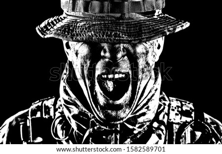 Commando fighter, elite troops soldier in camo uniform, bending head, hiding eyes behind bonnie hat, clenching teeth with anger and aggression, low key, studio portrait isolated on black background