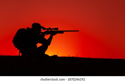 Commando Team Sniper, Army Special Forces Shooter Aiming, Shooting Sniper Rifle While Sitting On Sea Or Ocean Shore During Sunset. Coast Or Border Guard Soldier Observing Coastline With Optical Sight