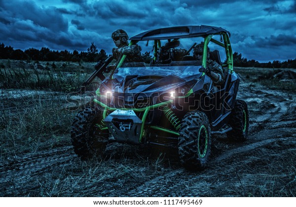 Commandos quick reaction group, special\
operations forces mobile team riding on fast attack vehicle or\
military sandrail during night patrolling in bad weather\
conditions. Raid under cover of\
darkness