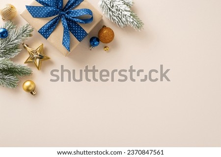Commemorate New Year in elegance. Top-view perspective of carefully wrapped giftbox, chic tree ornaments, glittery balls, seasonal adornments on beige backdrop, awaiting your personal message or promo