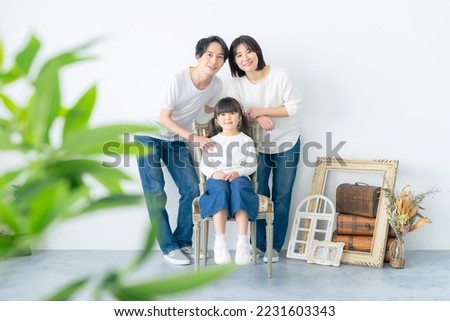 Commemorative photo of Asian parents and little girl. Photo studio.