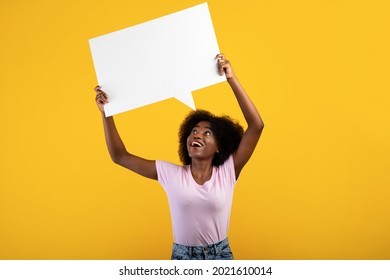 Comment. Positive african american lady having idea or thought, holding blank speech bubble cloud above her head. Free place for your text, yellow background, empty space - Powered by Shutterstock