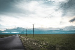 Commerce City, Colorado, United States - 5.25.2023: Rocky Mountain Arsenal National Wildlife Refuge. The Great Plains. Front Range Mountains In The Distance. Long And Empty Road, Utility Poles