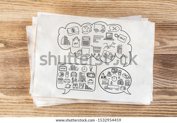 Commercial activity pencil hand drawn with group\
of business doodles in speech bubbles. Financial planning and\
management symbols on white page. Workplace with paper and pencil\
on wooden surface.