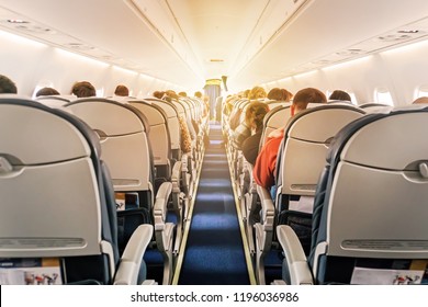 Commercial aircraft cabin with rows of seats down the aisle. morning light in the salon of the airliner. economy class