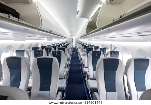 Commercial aircraft cabin with rows of seats down\
the aisle