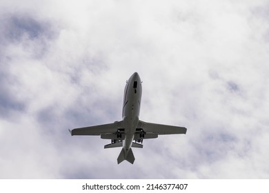 A Commercial Aircraft Landing At An Airport Against An Afternoon Sky