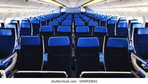commercial airplane cabin interior with blue seats.