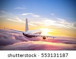Commercial airplane flying above clouds in dramatic sunset light. Very high resolution of image