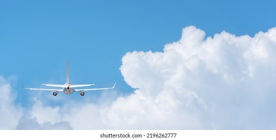 Commercial Airplane Flying Above Clouds On Day Light, Clear Blue Sky And Fluffy Soft White Cloud With Copy Space, Travel Vacation Trip Concept