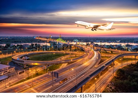 Commercial airplane flying over Beautiful night city, cityscape of Nonthaburi bridge in Bangkok Thailand road for transportation at twilight