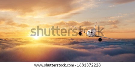 Commercial airplane flying over dramatic sunset sky. Jet plane is the fastest mode of modern transportation.