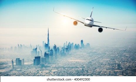 Commercial airplane flying over modern city