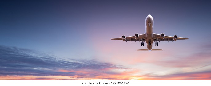 Commercial airplane jetliner flying above dramatic clouds in beautiful sunset light  Travel concept 
