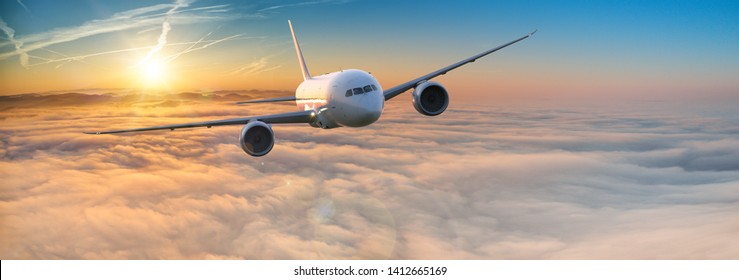 Commercial Airplane Jetliner Flying Above Dramatic Clouds In Beautiful Light. Travel Concept.