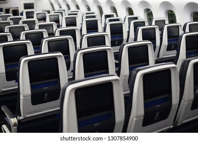  commercial airplane seats viewed from the rear. Inflight entertainment screens