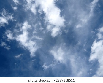 A commercial airplane is soaring through a picturesque sky, with white, fluffy clouds below
