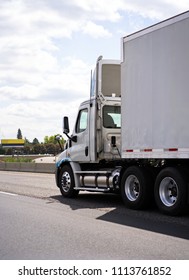 Commercial Big Rig White Day Cab Local Haul Semi Truck With Roof Spoiler Transporting Dry Van Semi Trailer On The Highway Road For Delivery Of Industrial Cargo To Warehouse Or Local Business