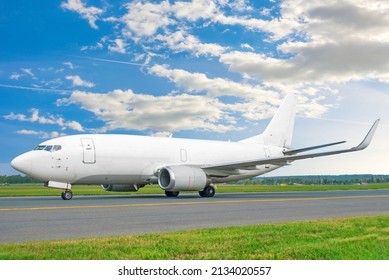 Commercial Cargo Freight Liner Aircraft Without Windows Taxis On The Steering Track Against The Background Of The Sky And Clouds