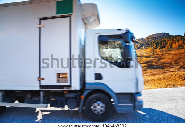 Commercial cargo transportation\
truck going by mountain road in Dolomite Alps in South Tyrol,\
Italy.