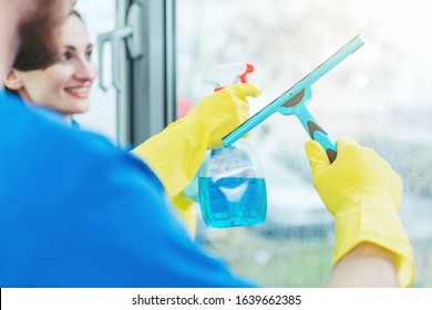 Commercial Cleaners Cleaning An Office Window Wearing Gloves