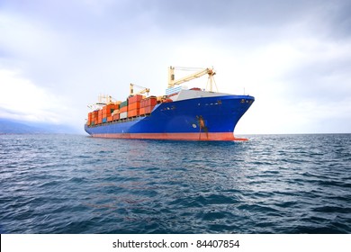 commercial container ship with dramatic sky