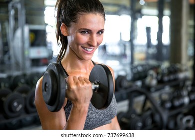 Commercial Female Model With Perfect Smile Lifting Weights Curling Dumbbell For Toned Fit Arms