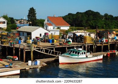 The Commercial Fishing Fleet Is Docked On A Pier With Lobster Traps And Buoys Along The New England Coast