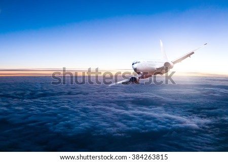 Commercial jet aeroplane flying above clouds