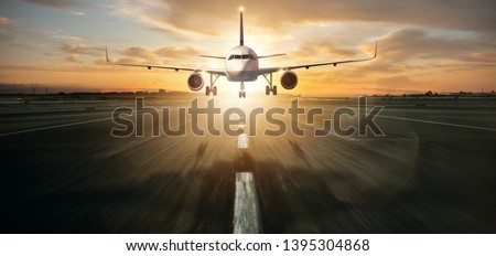 Commercial jetliner landing on runway. Modern and fastest mode of transportation. Dramatic sunset sky on background