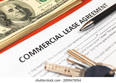 Commercial Lease Agreement Form Close-up. House Keys, Pen And Money On Office Desk. Close-up Photo