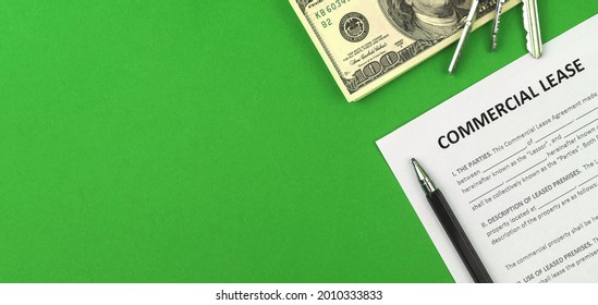 Commercial Lease Agreement. Table With Finance And Business Document, House Keys, Pen And Money. Green Background, Banner And Copy Space Photo